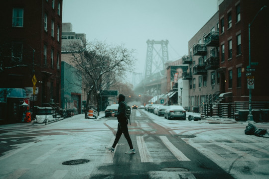 A person walking across a snow covered street