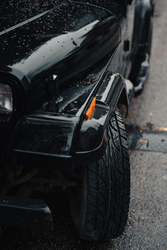 A close up of a black jeep parked on the side of a road