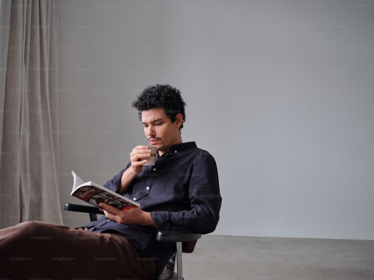 A man sitting in a chair reading a book