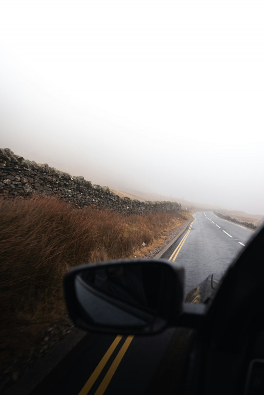 A car driving down a road in the fog