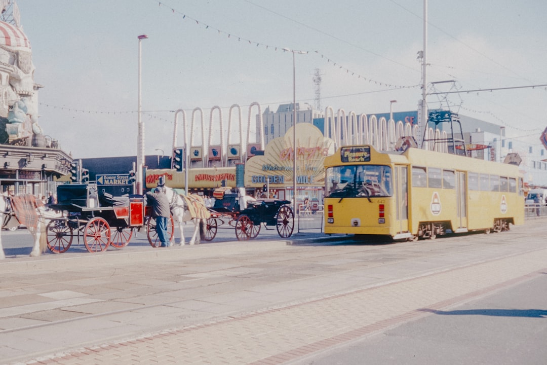 A yellow bus driving down a street next to tall buildings