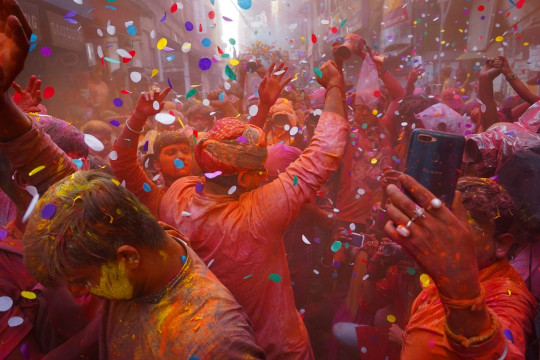 A group of people celebrating with colored powder and confetti