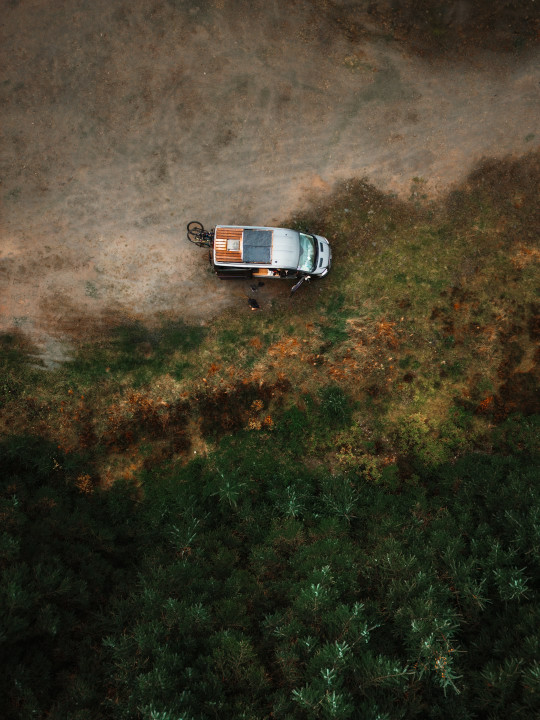 An aerial view of a truck driving down a dirt road