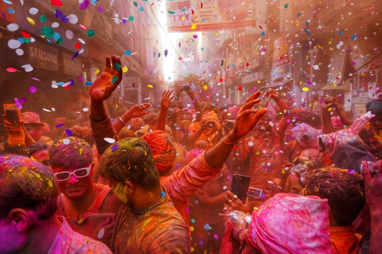 A group of people celebrating with colored powder and confetti