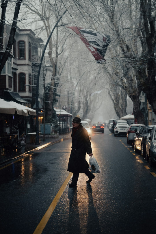 A person walking down a street holding a bag