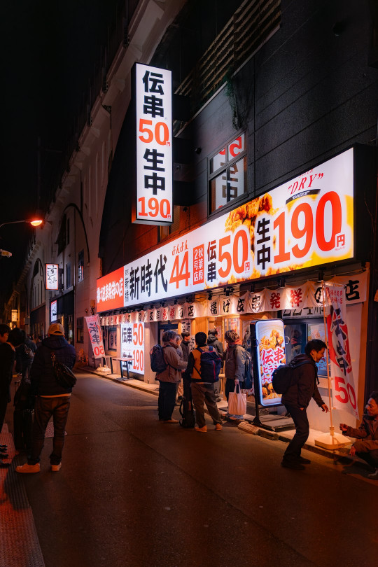 A group of people walking down a street at night