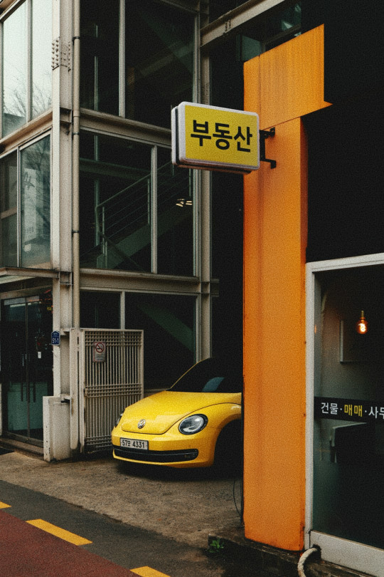 A yellow car parked in front of a building