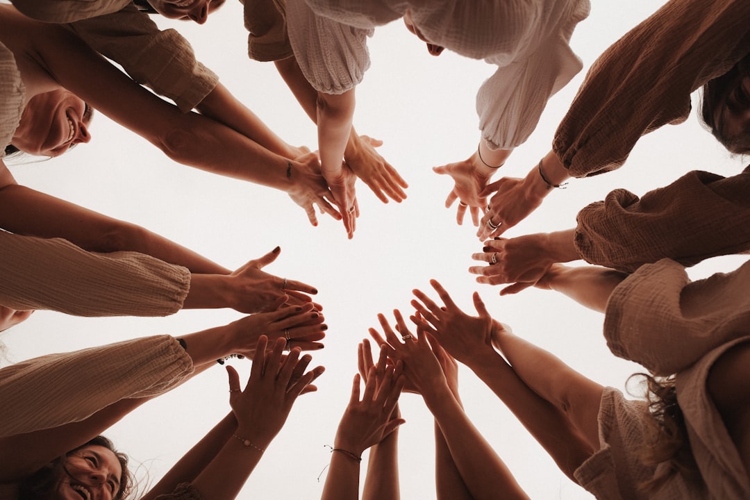 A group of people standing in a circle with their hands together