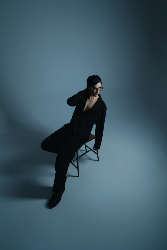 A woman sitting on a chair in a dark room