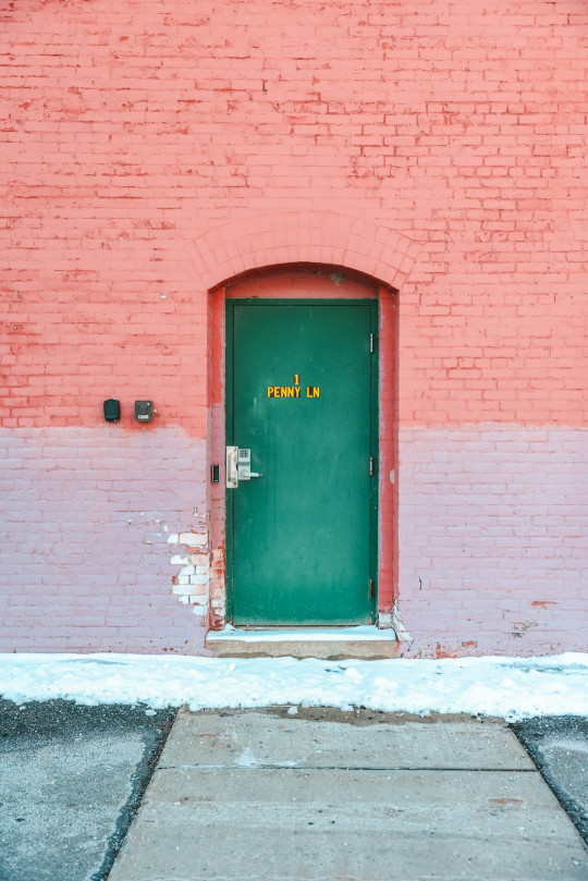 A red brick building with a green door