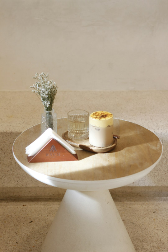 a table with a cup of coffee and a book on it