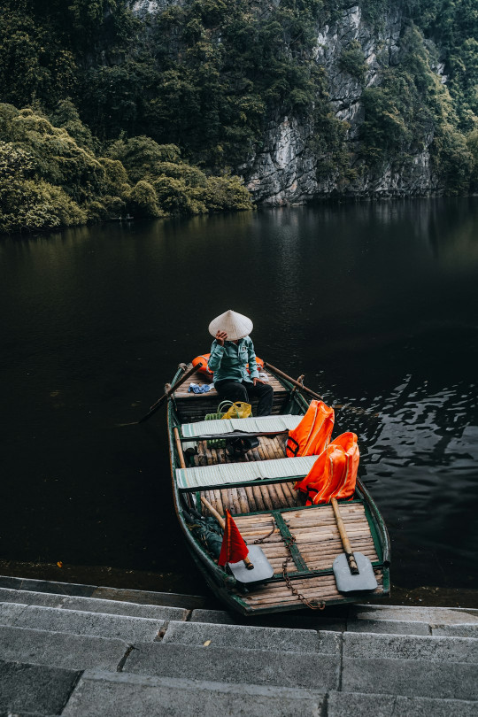 A man sitting in a small boat on a river