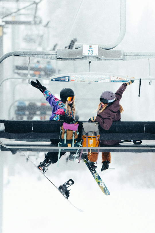 A couple of people riding a ski lift