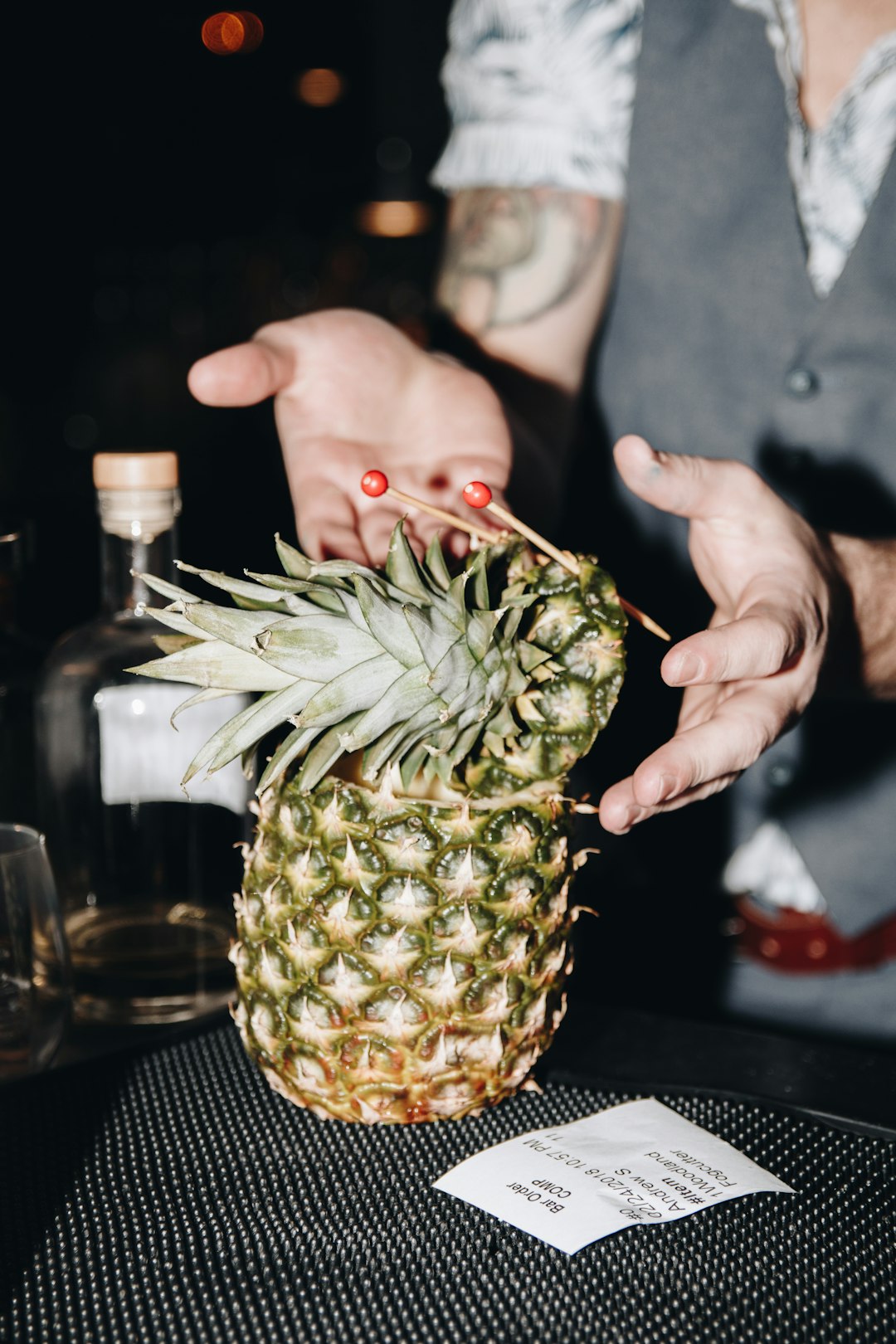 A person holding a pineapple on top of a table