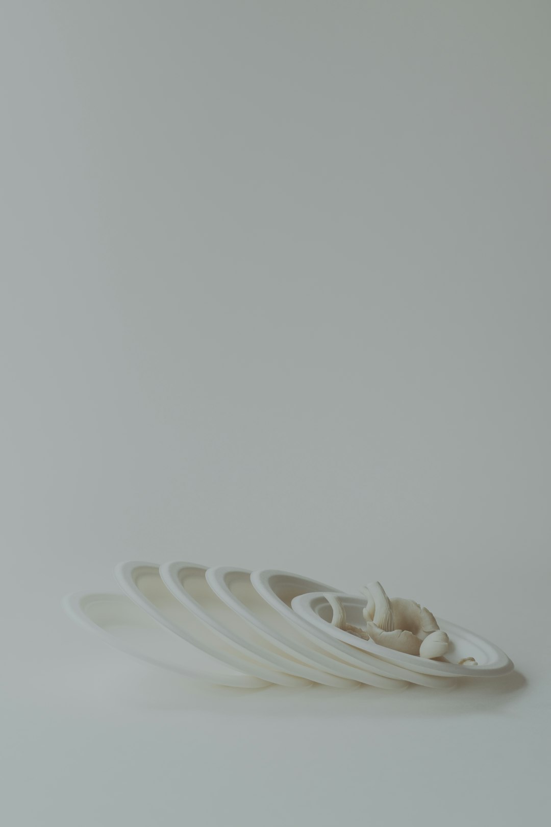 A stack of white plates sitting on top of a white table