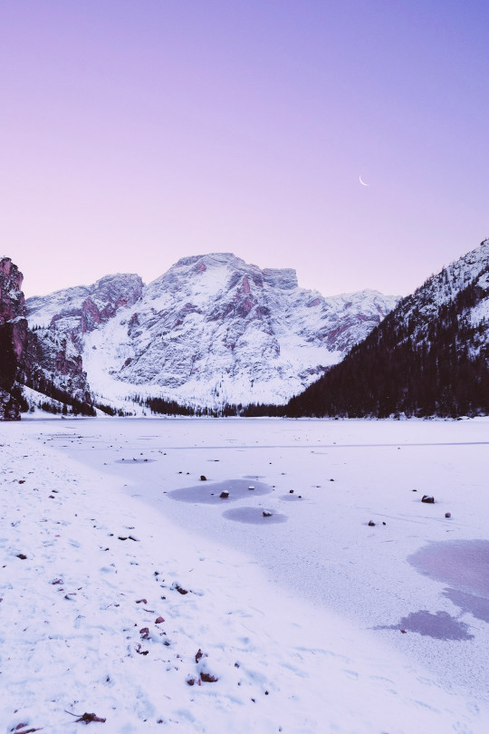 A snow covered field with mountains in the background