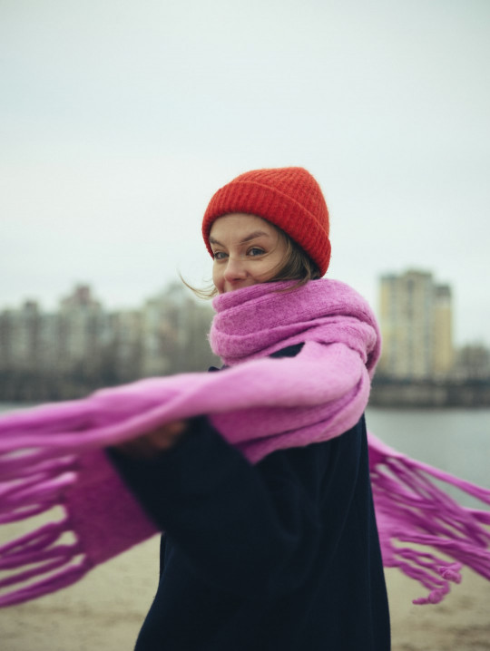 A woman wearing a pink scarf and a red hat