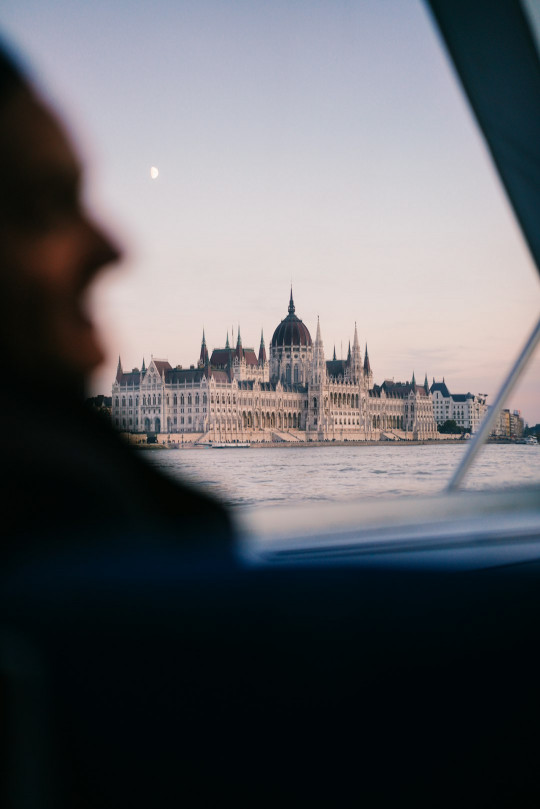 A man driving a boat in front of a castle