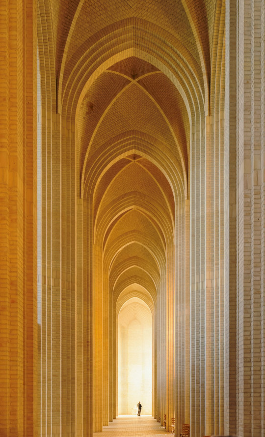 A long hallway with a person walking down it