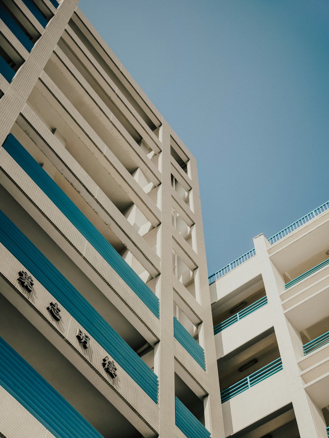 A tall white and blue building with balconies