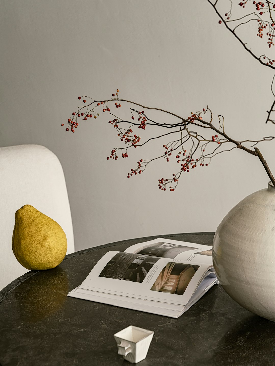 A table with a vase and a magazine on it