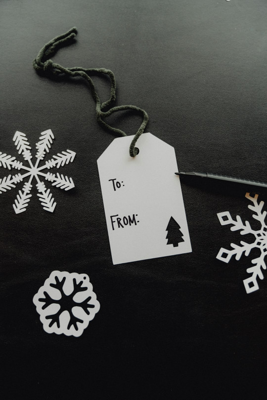 A black table topped with snowflakes and tags