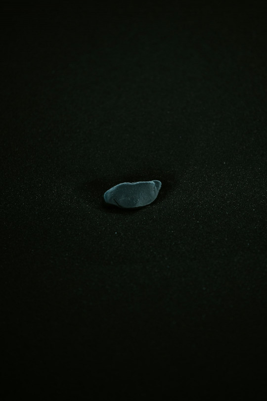 A black surface with a small piece of glass on it