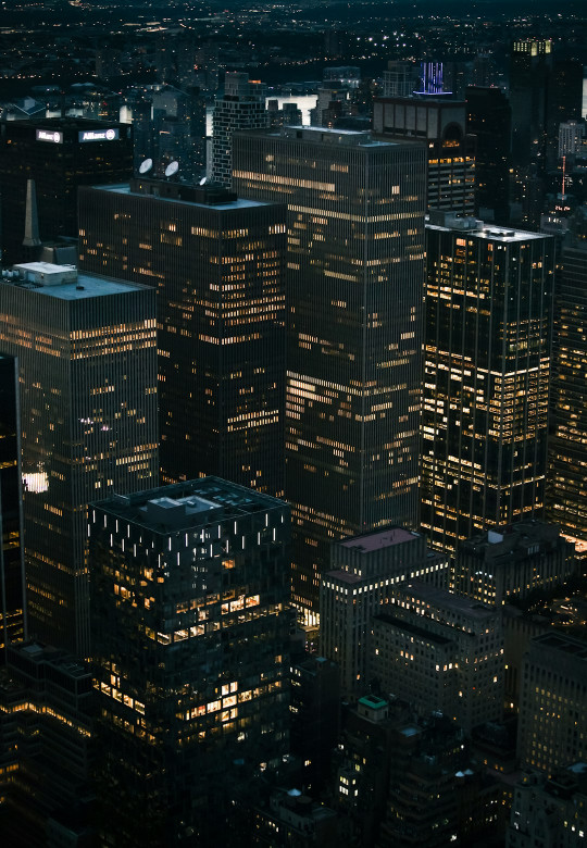 A view of a city at night from the top of a skyscraper