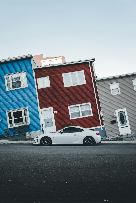 A car parked in front of a row of houses