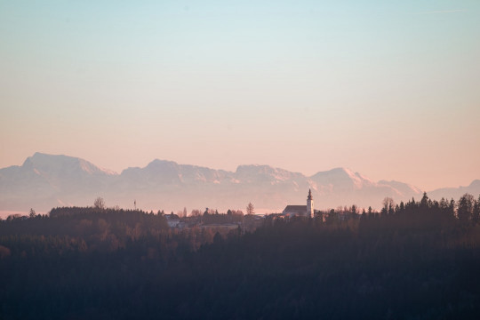 A view of a mountain range with a church in the foreground