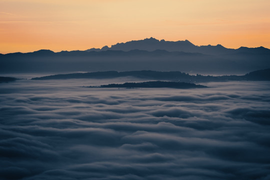 A view of a mountain covered in clouds