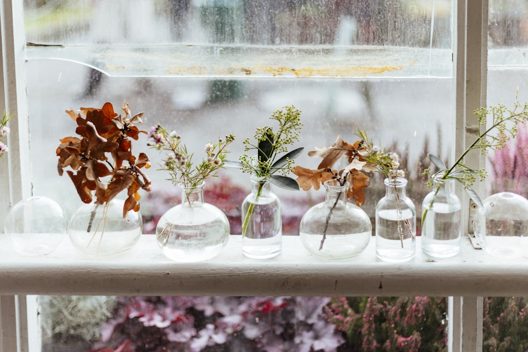 A window sill filled with vases filled with flowers