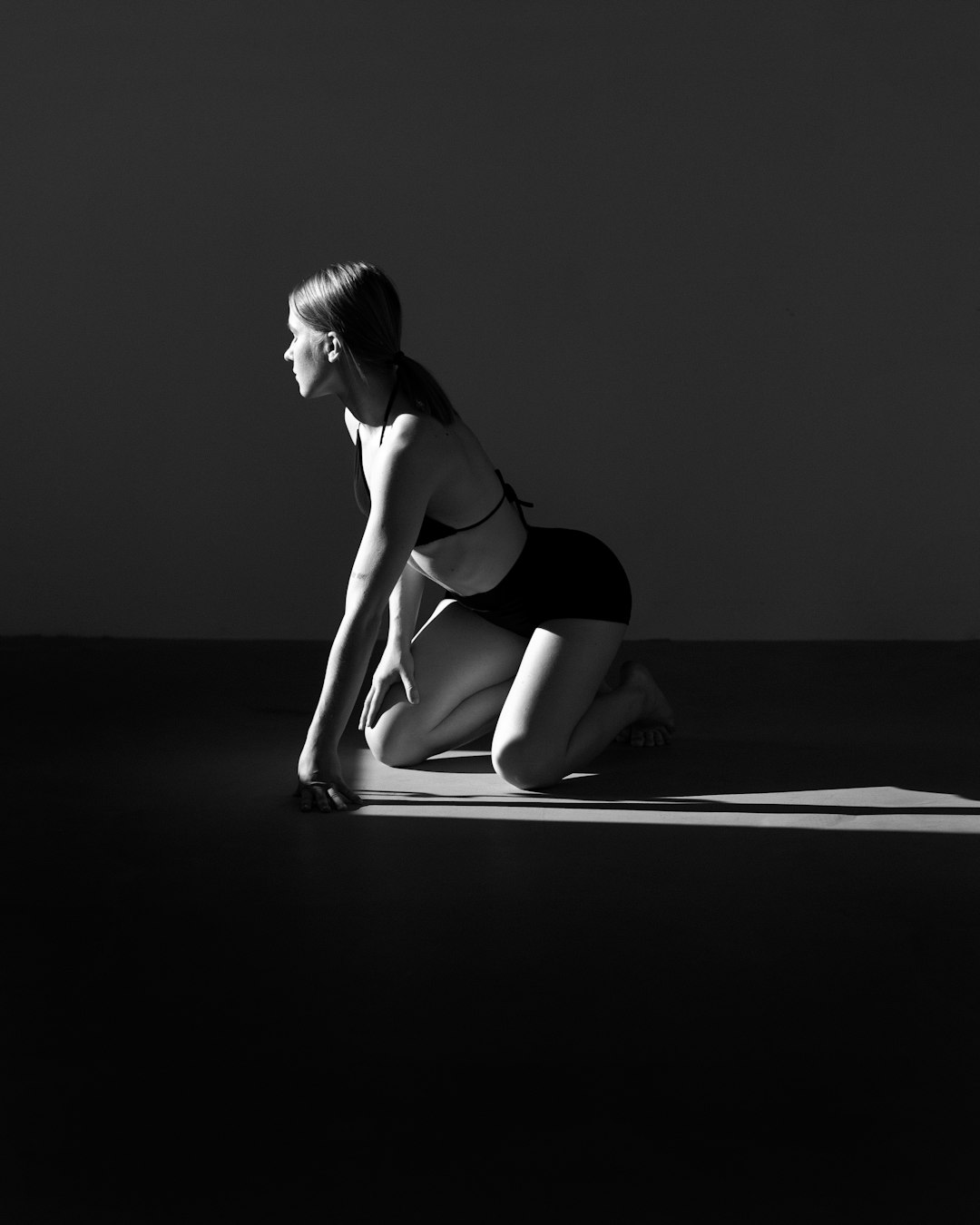 A woman in a black and white photo kneeling down