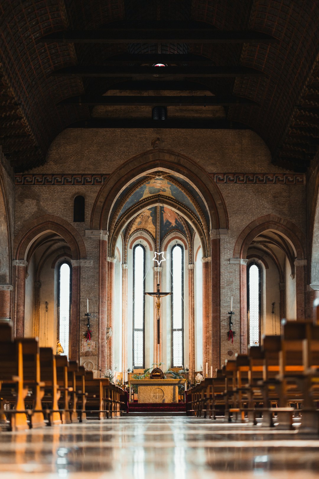 A church filled with lots of pews next to tall windows