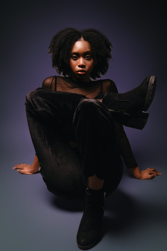 A woman sitting on the ground with her legs crossed