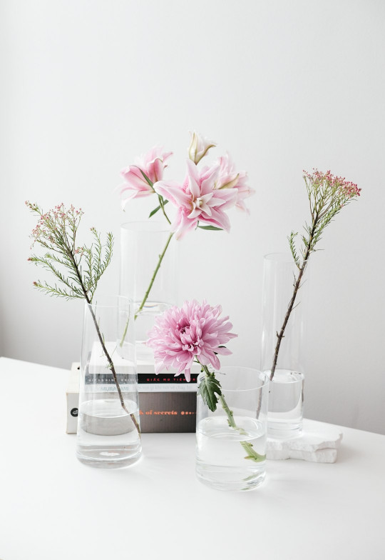 A white table topped with vases filled with flowers