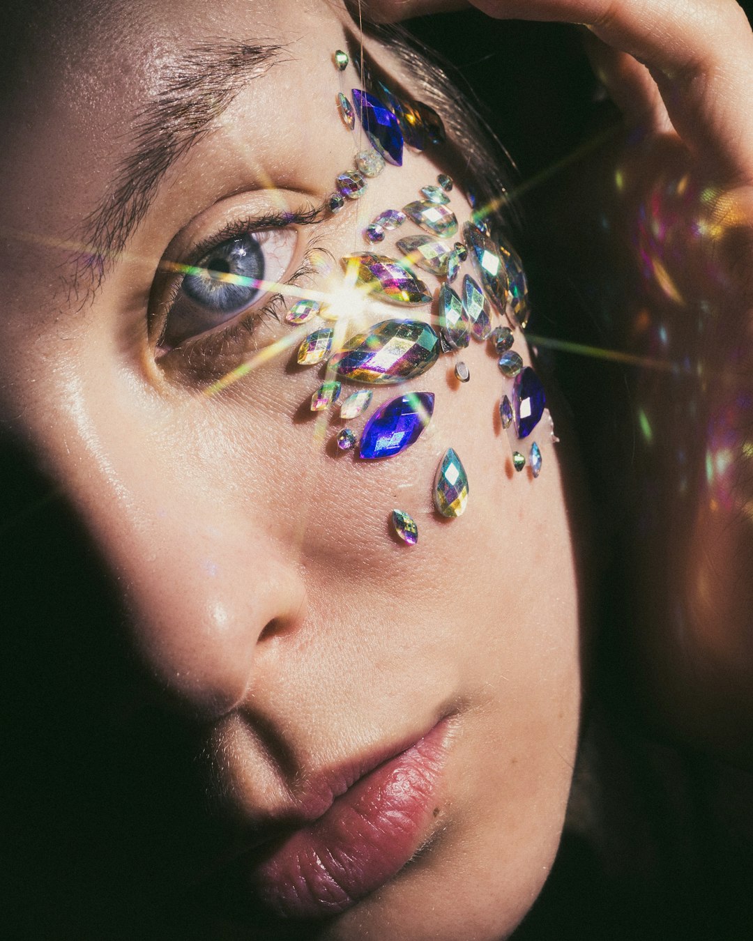 A close up of a woman's face with jewels on her face