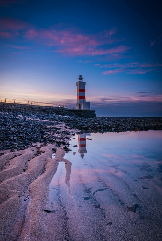 A light house sitting on top of a sandy beach