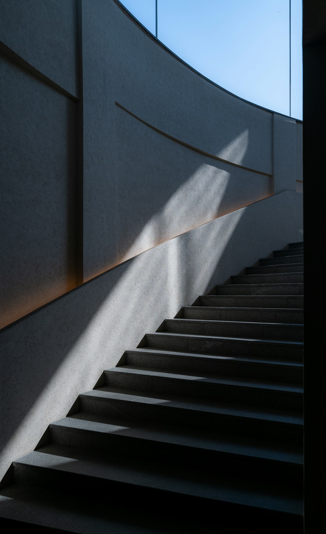 A staircase with a shadow of a building on the wall