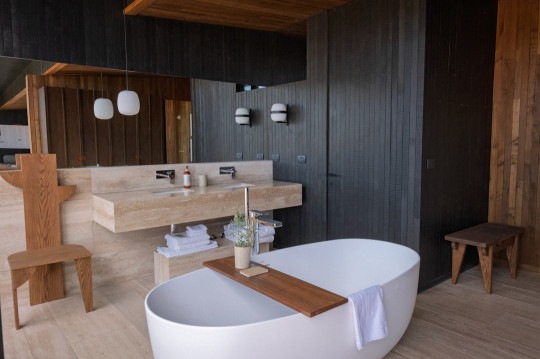 A bathroom with a large tub and a sink