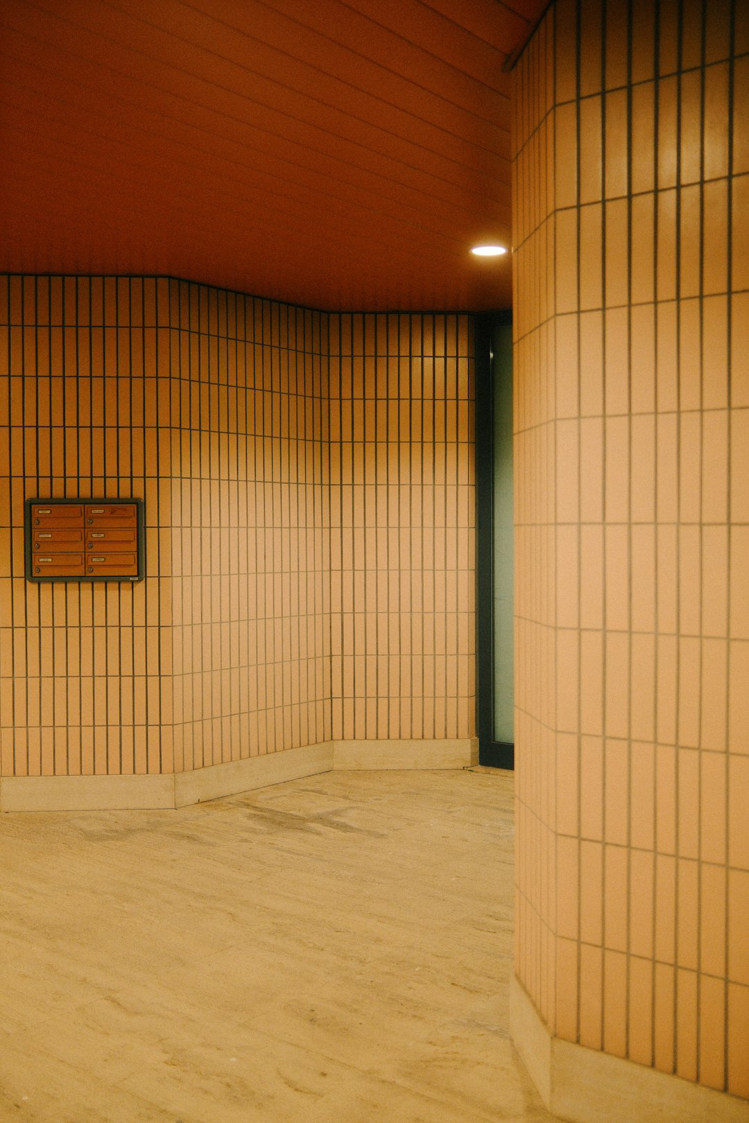 An empty room with tiled walls and wooden floors