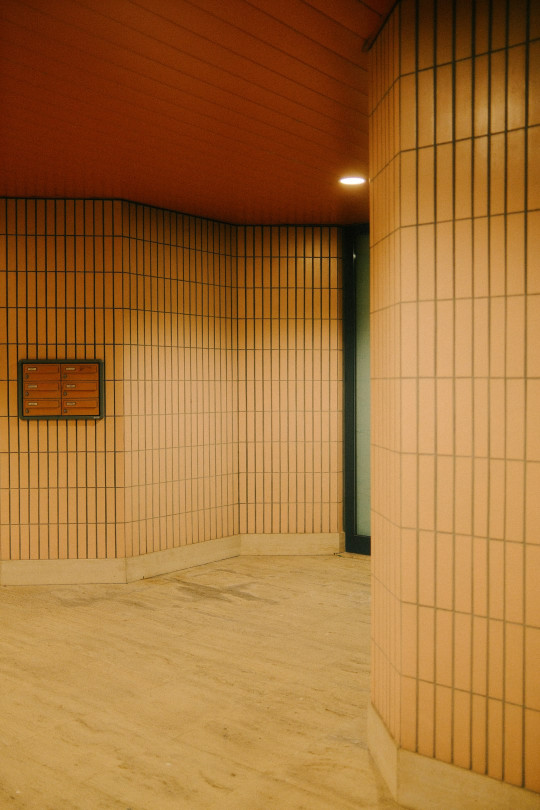 An empty room with tiled walls and wooden floors