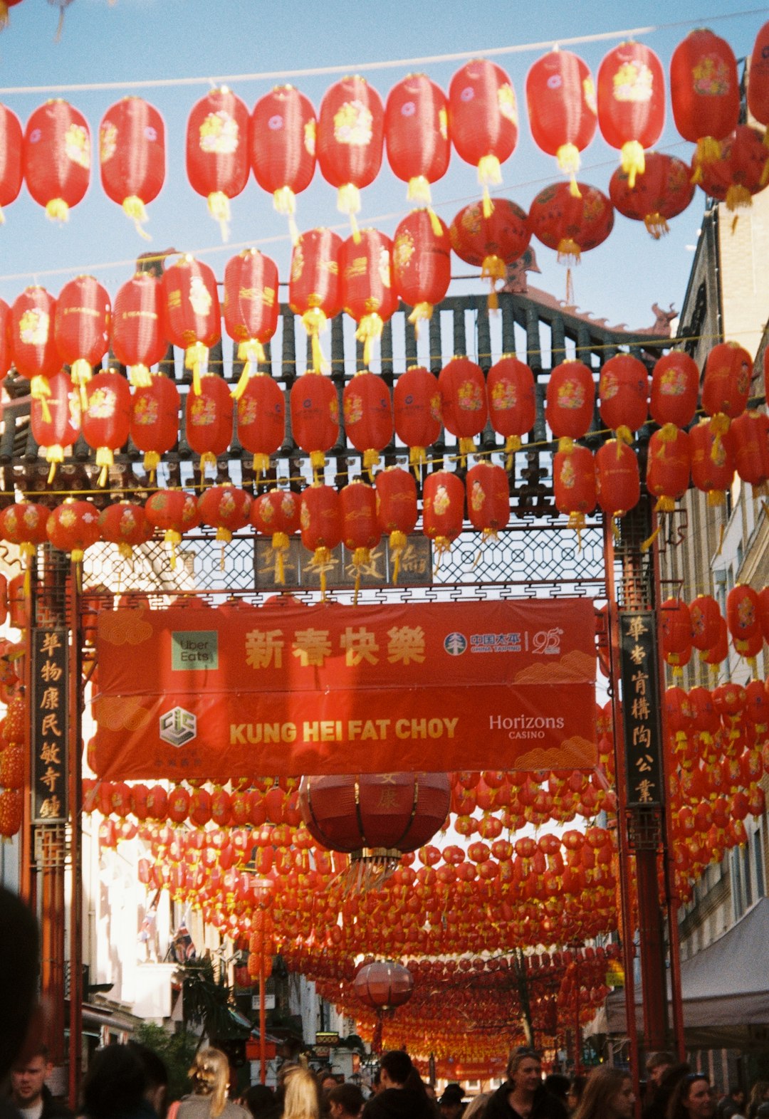 A group of people walking under red lanterns