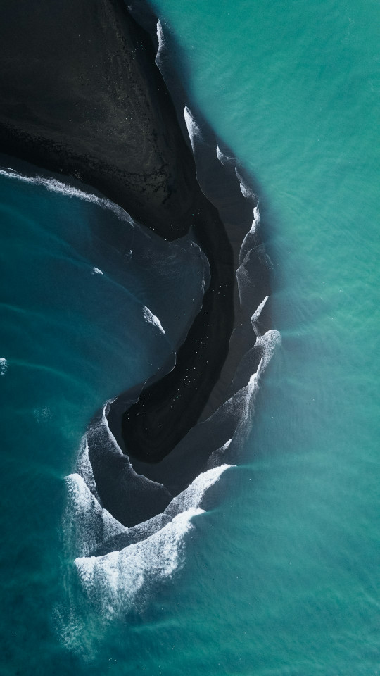 An aerial view of a black sand beach