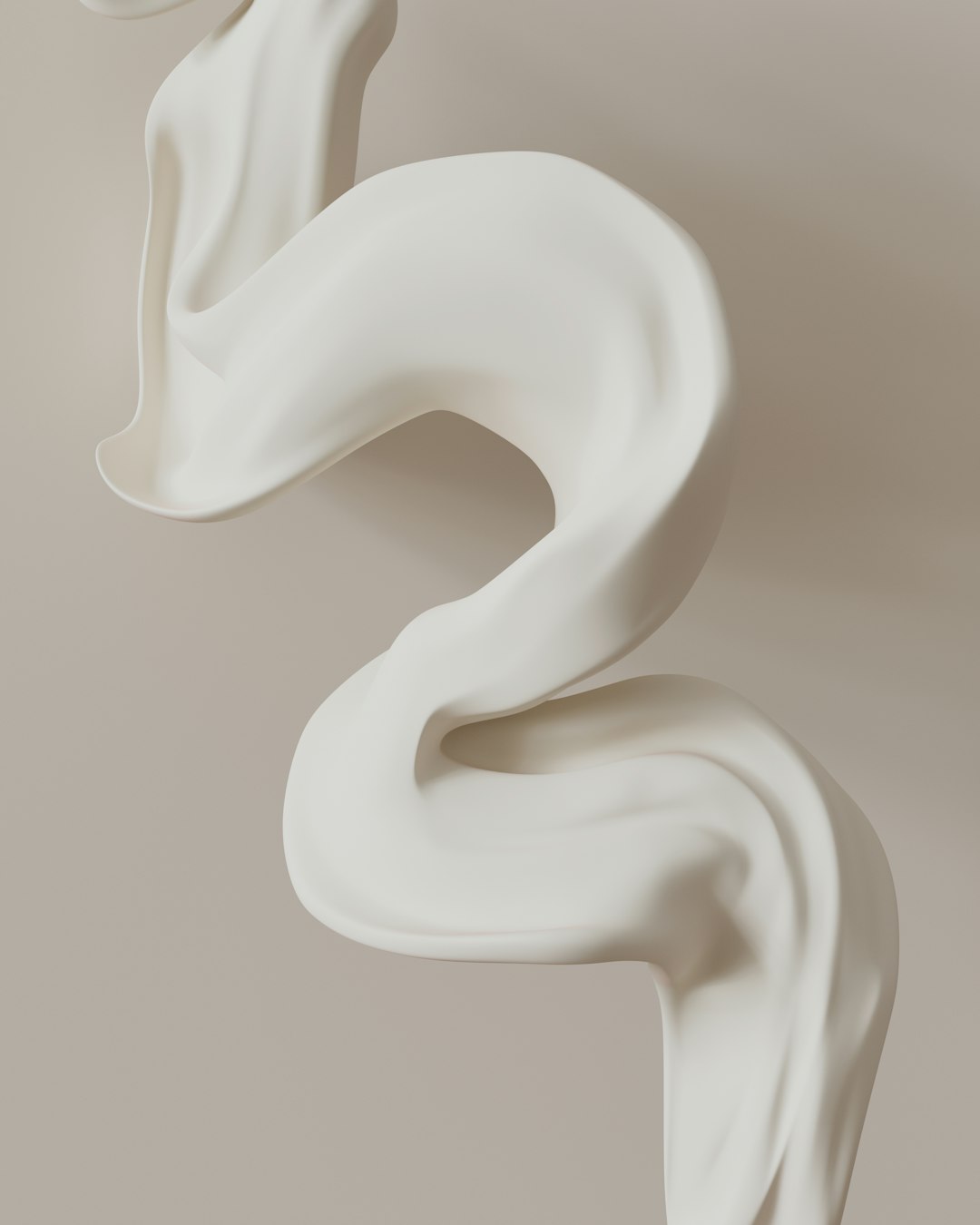 A white sculpture of a swirl on a wall