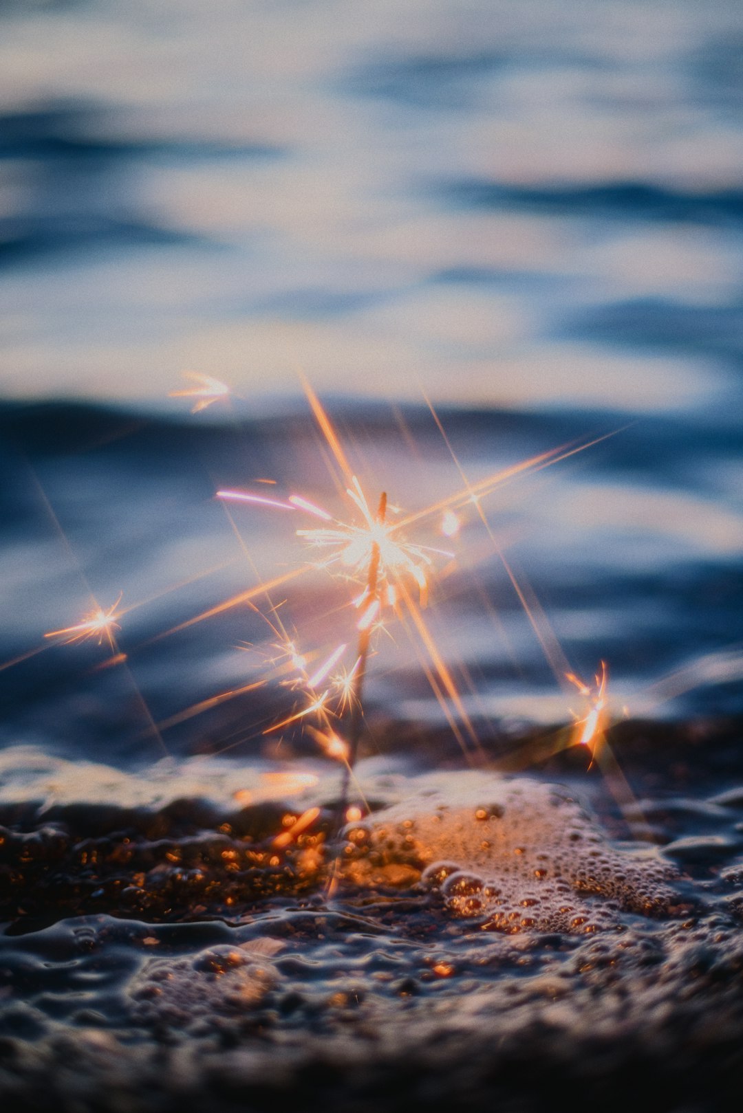 A close up of a sparkler in the water