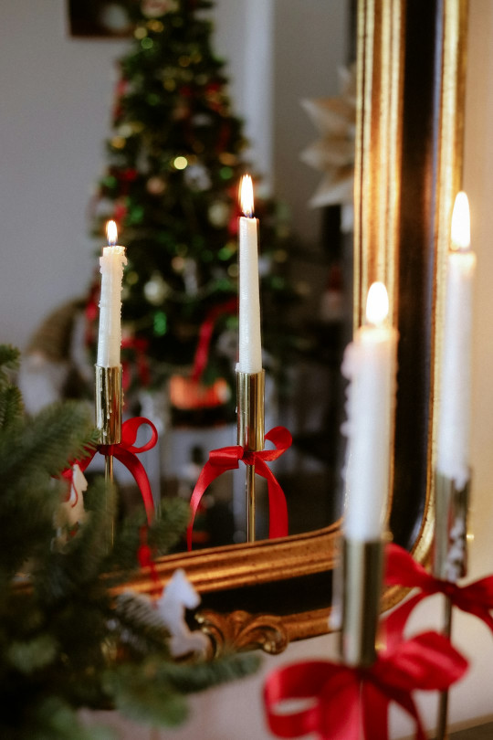 A christmas tree is in front of a mirror