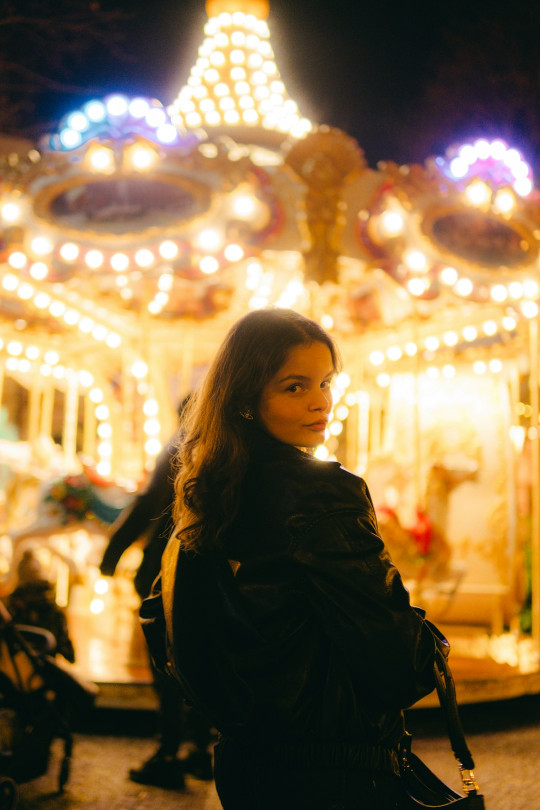 A woman standing in front of a merry go round