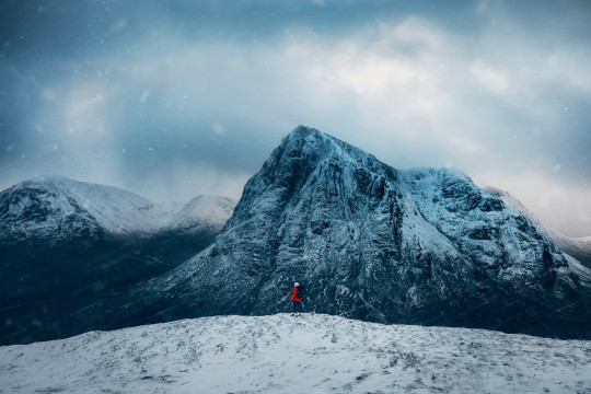 A person standing on top of a snow covered mountain