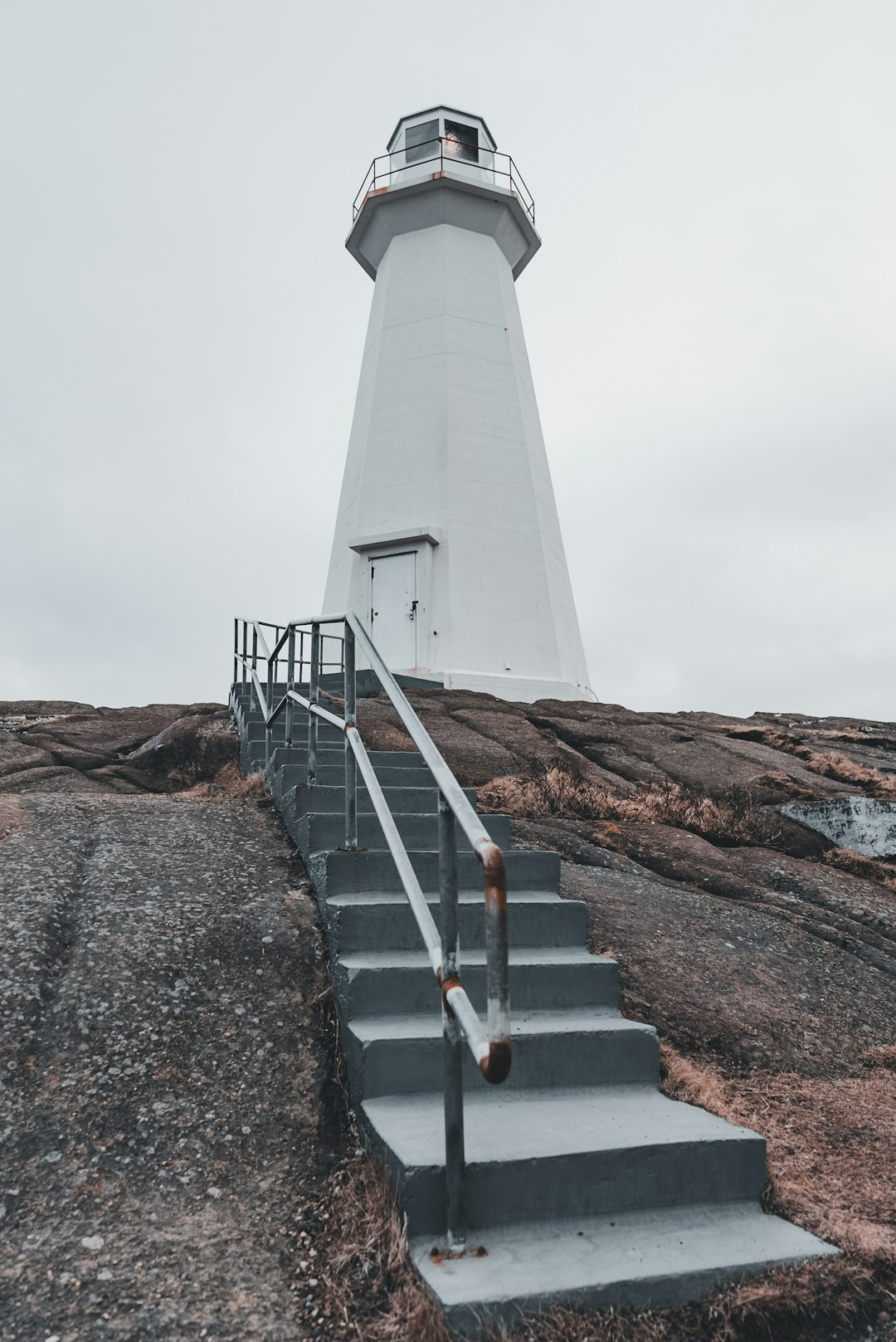 A lighthouse on top of a rocky hill